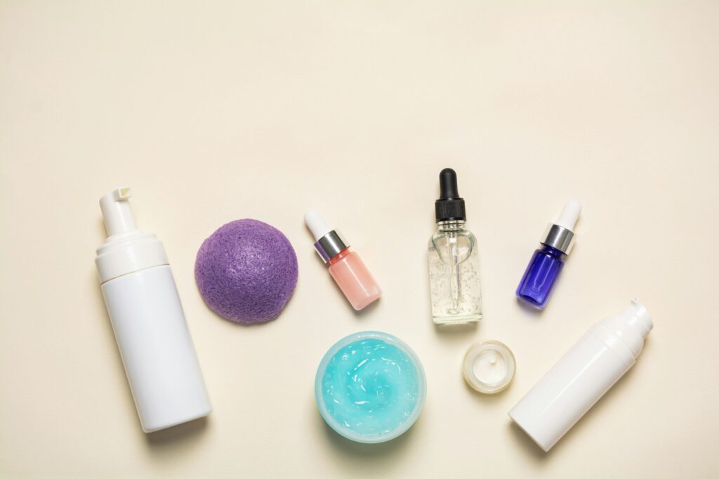 Facial cosmetic products and konjac sponge on a beige background