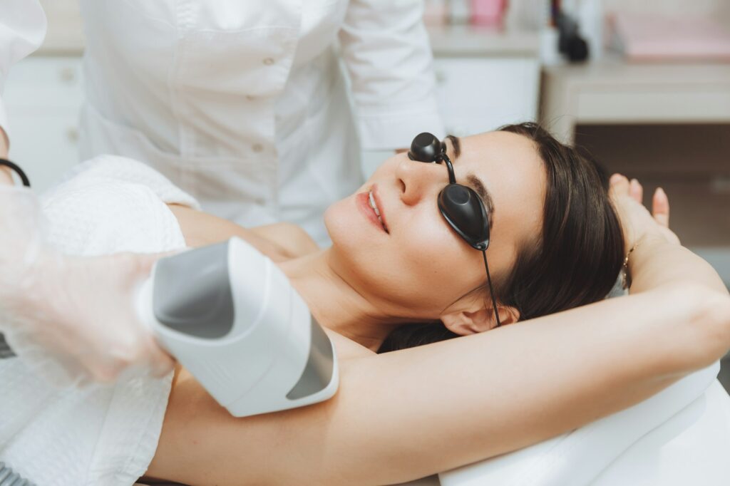 a cosmetologist does laser hair removal of the armpits in the salon