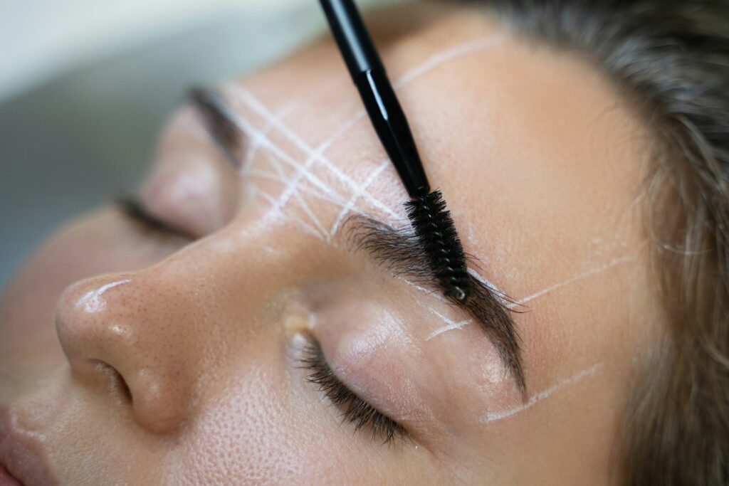 Woman during professional eyebrow mapping procedure